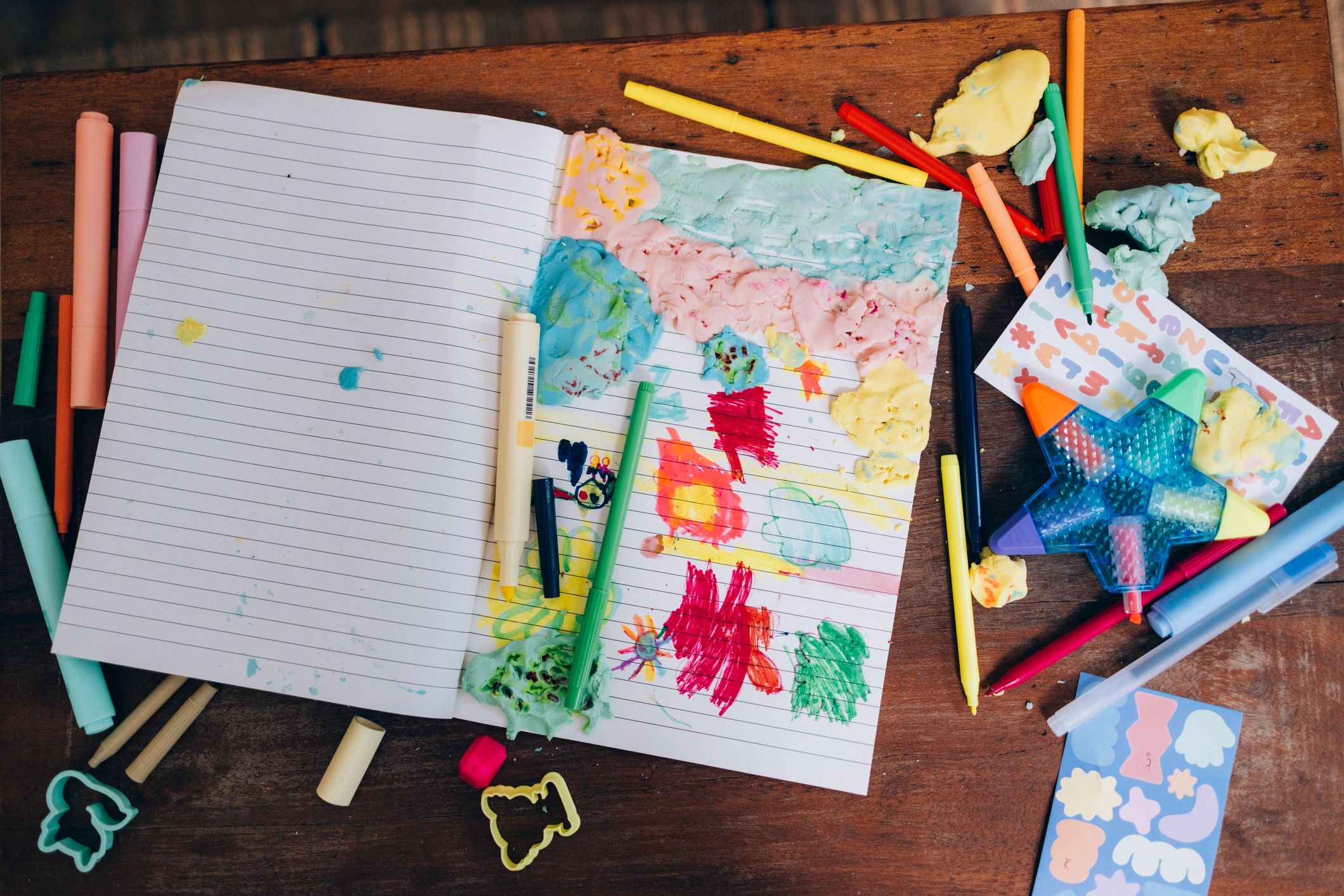 Notebook with childlike drawings and markers